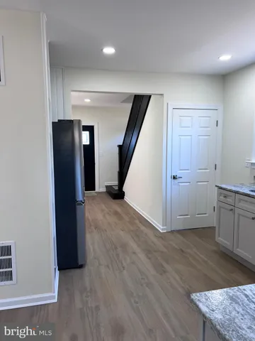 a view of an empty room with closet and wooden floor