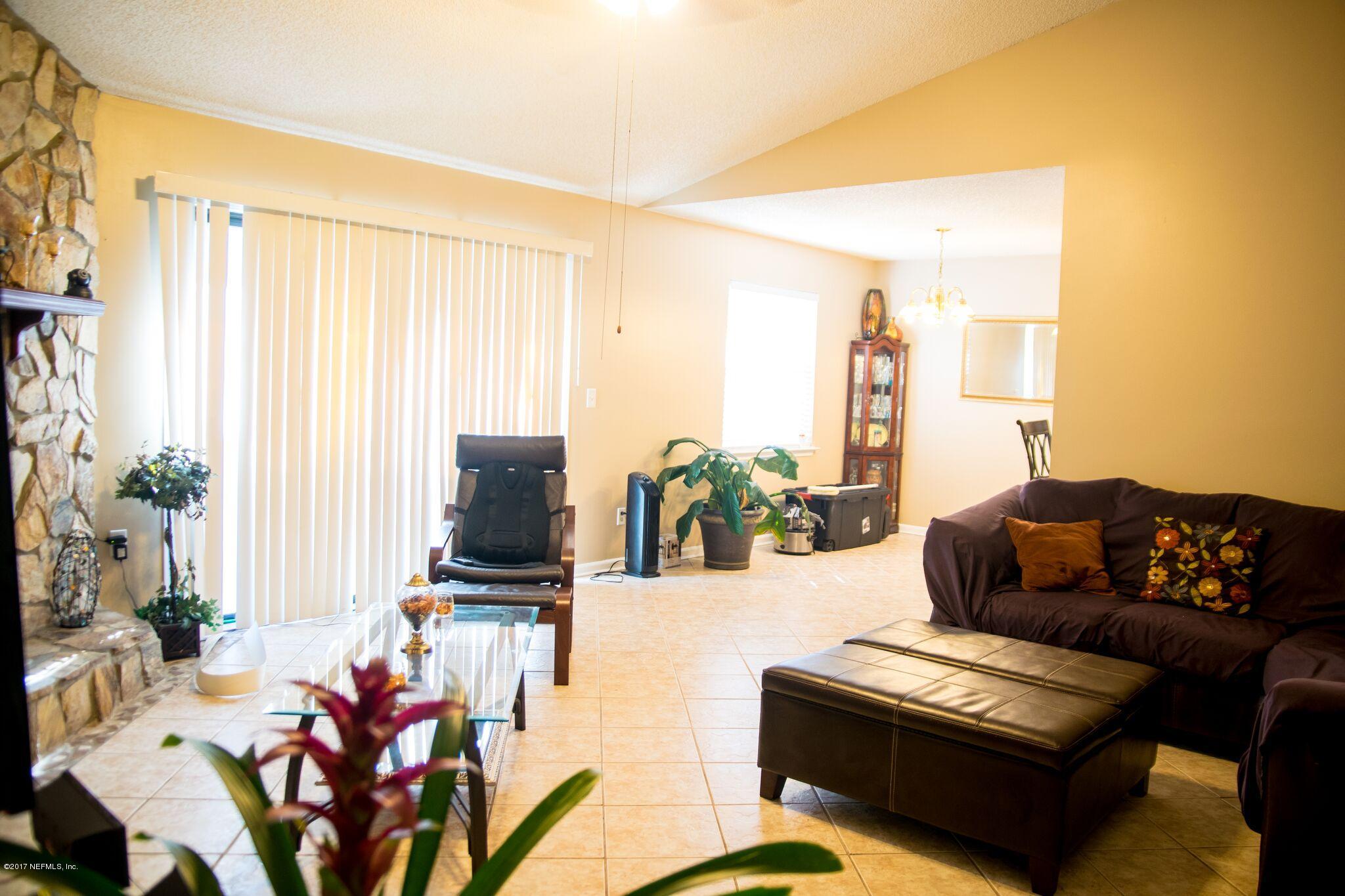 10775 Rutgers Road Jacksonville, FL 32218 - Photo 1 of 10 a living room with furniture and a flat screen tv