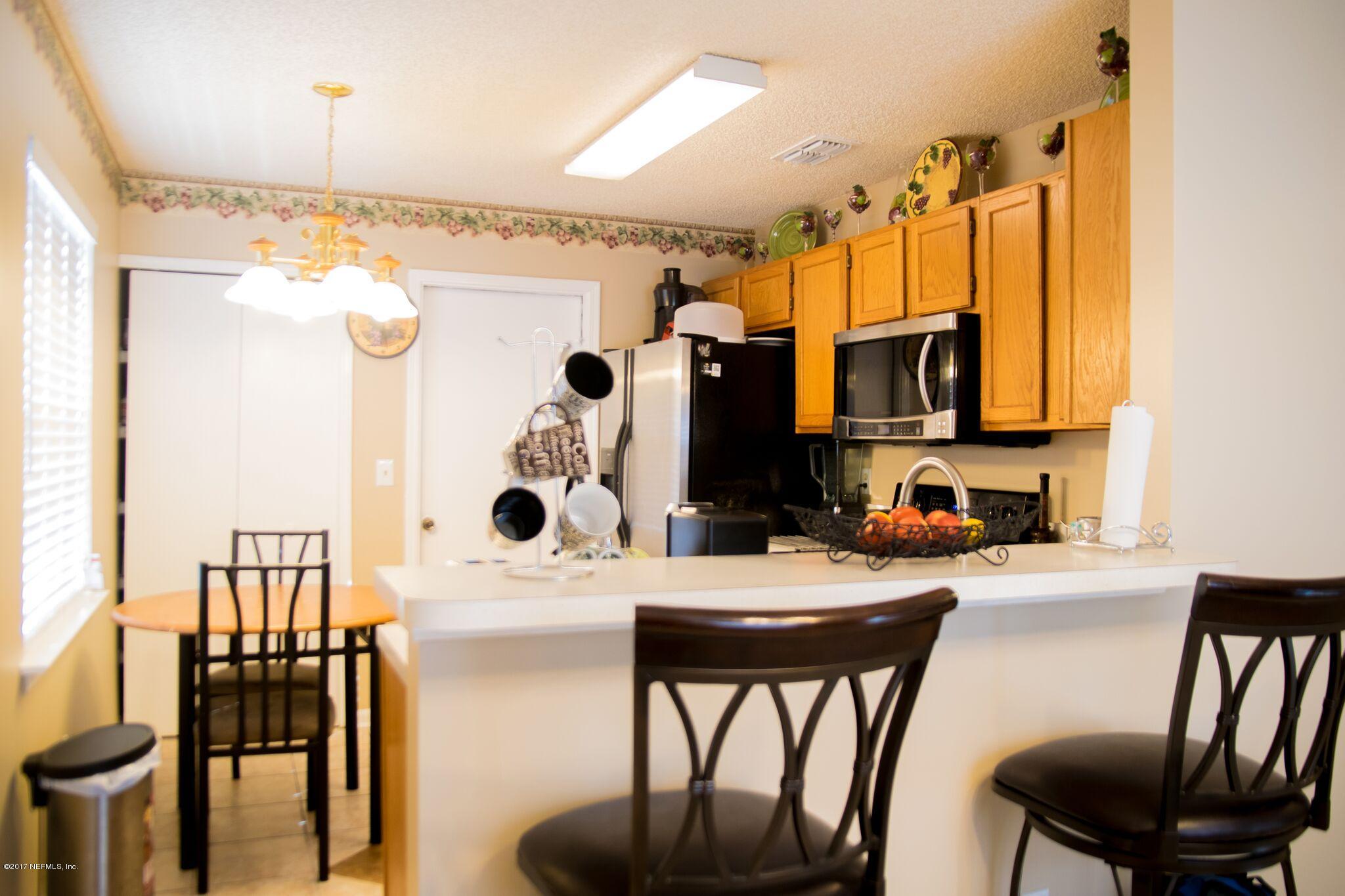 10775 Rutgers Road Jacksonville, FL 32218 - Photo 7 of 10 a kitchen with stainless steel appliances kitchen island granite countertop a table chairs and a refrigerator