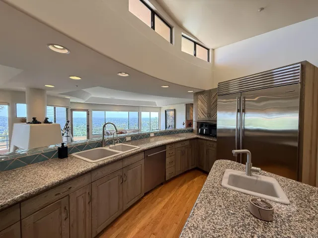 a kitchen with granite countertop a sink and a refrigerator