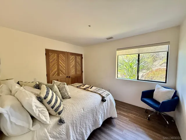 a bedroom with furniture and a large window