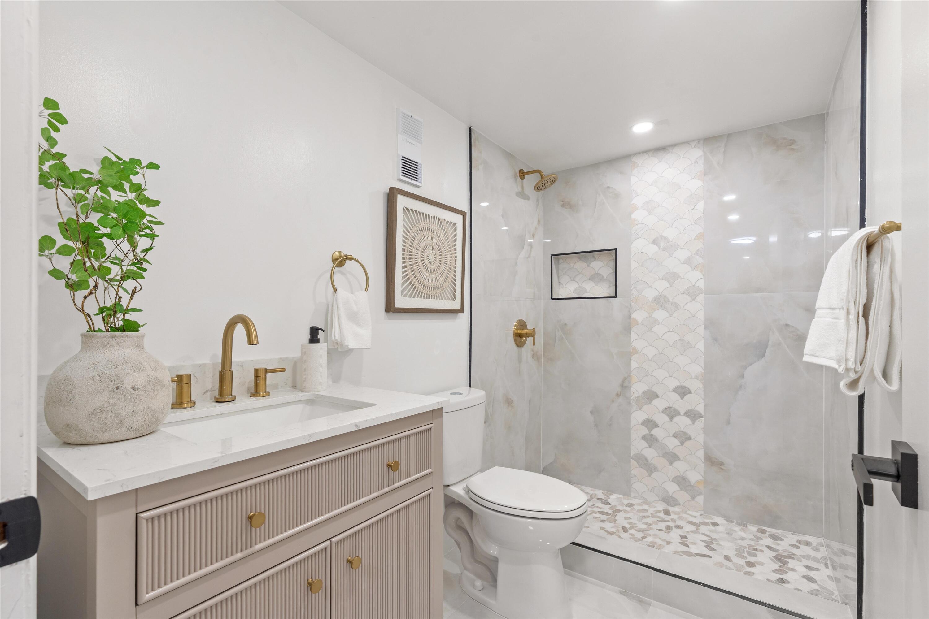 755 Dotterel Road, Unit 1307 Delray Beach, FL 33444 - Photo 18 of 36 a bathroom with a granite countertop sink a toilet and shower