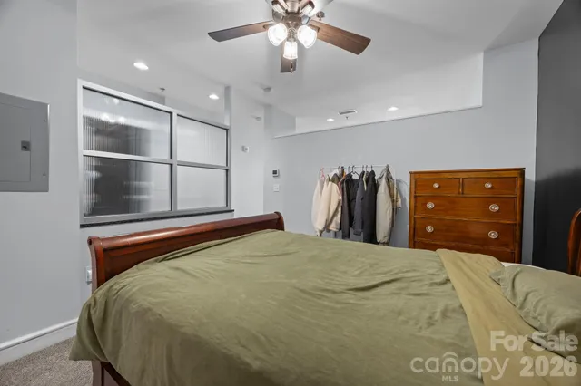 a bed room with a bed and a ceiling fan
