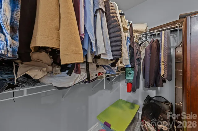 a view of walk in closet with clothes and shoes