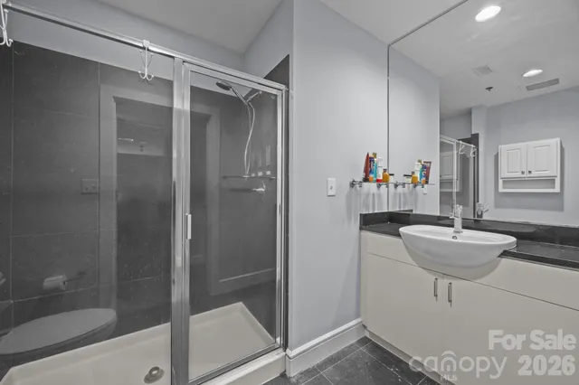 a bathroom with a granite countertop sink a toilet and shower