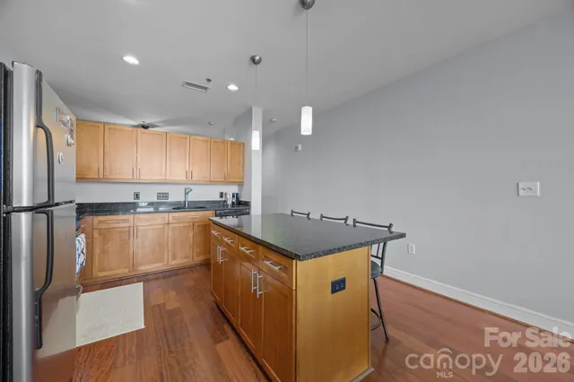 a kitchen with granite countertop a sink a counter space and stainless steel appliances