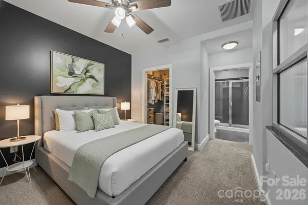 a bedroom with a large bed and a chandelier