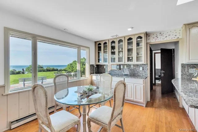 a kitchen with stainless steel appliances granite countertop a stove a sink dishwasher a dining table and chairs with wooden floor