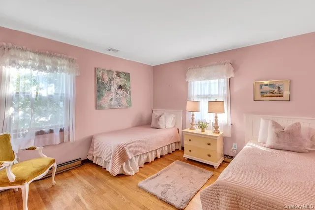 a view of swimming pool with lawn chairs plants and large tree