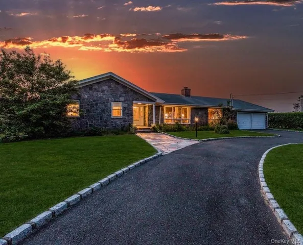 a front view of a house with a yard and green space