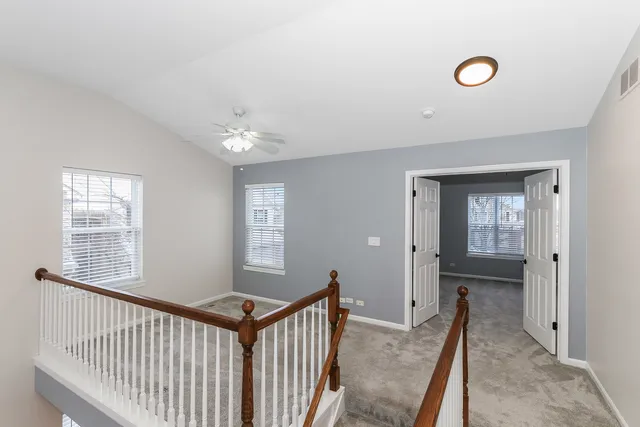 a view of a hallway to a bedroom with windows