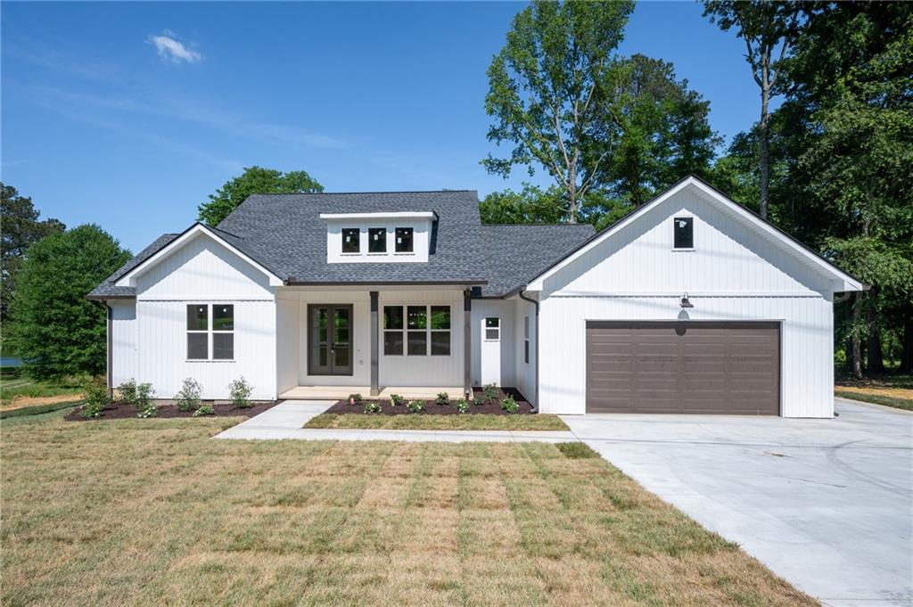 554 McDaniel Station Road Southwest Calhoun, GA 30701 - Photo 1 of 1 a front view of a house with a yard and garage