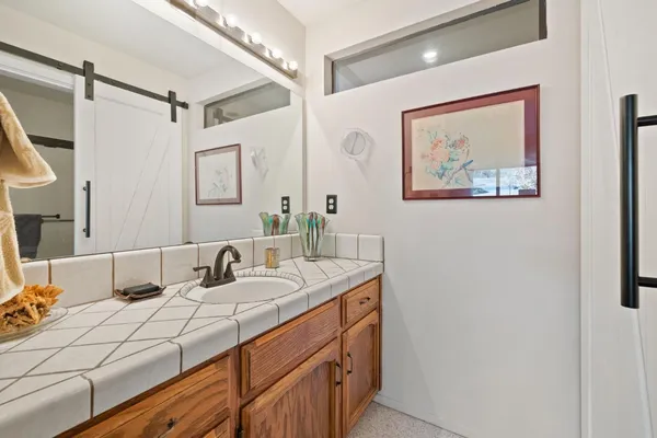 a bathroom with a granite countertop sink mirror vanity and toilet