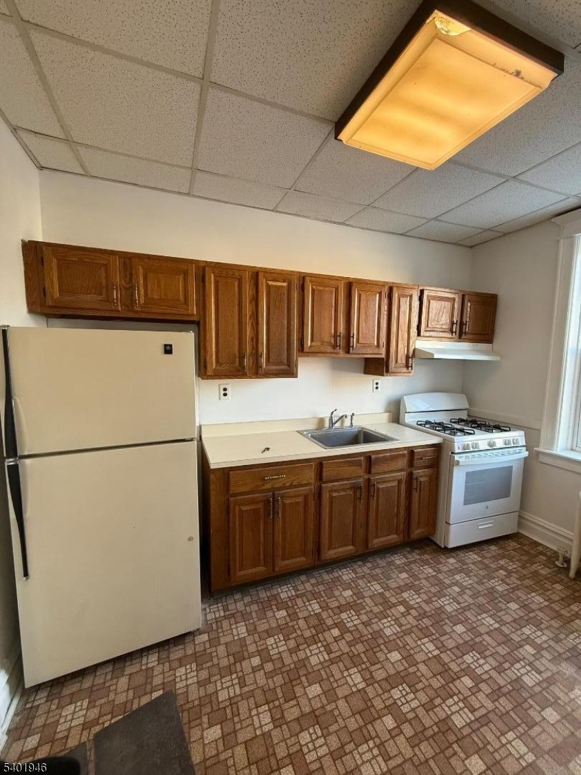 214 Lawton Avenue, Unit 1 Cliffside Park, NJ 07010 - Photo 5 of 6 a kitchen with granite countertop a refrigerator and a stove