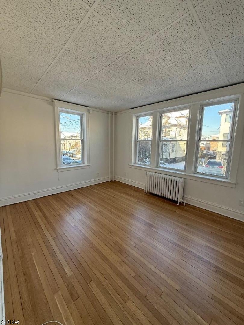 214 Lawton Avenue, Unit 1 Cliffside Park, NJ 07010 - Photo 6 of 6 a view of an empty room with wooden floor and a window