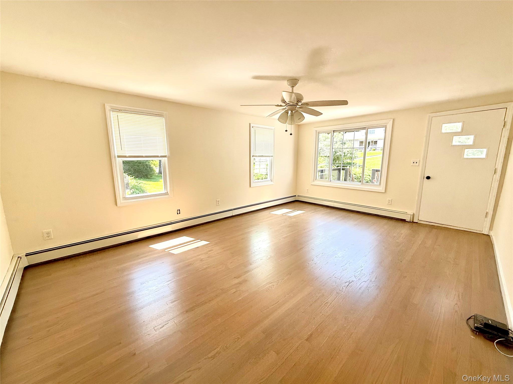 55 Red Mill Road Cortlandt Manor, NY 10567 - Photo 12 of 20 an empty room with wooden floor fan and windows