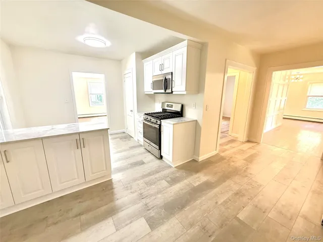 a view of a kitchen with wooden cabinet and stainless steel appliances