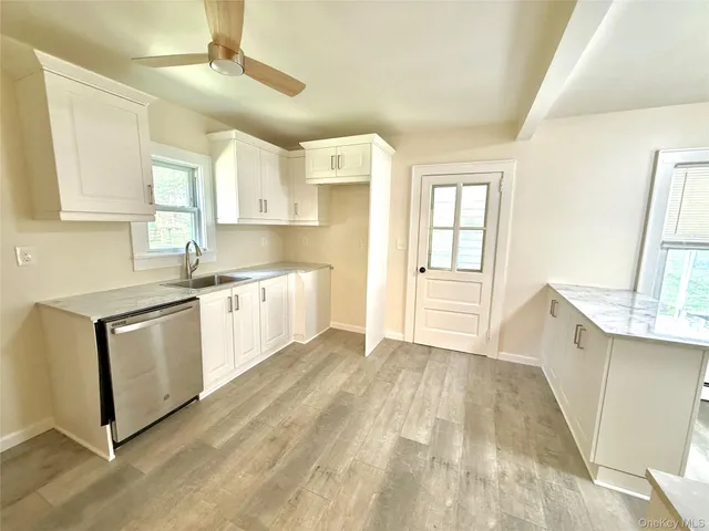 a kitchen with a sink a window and cabinets