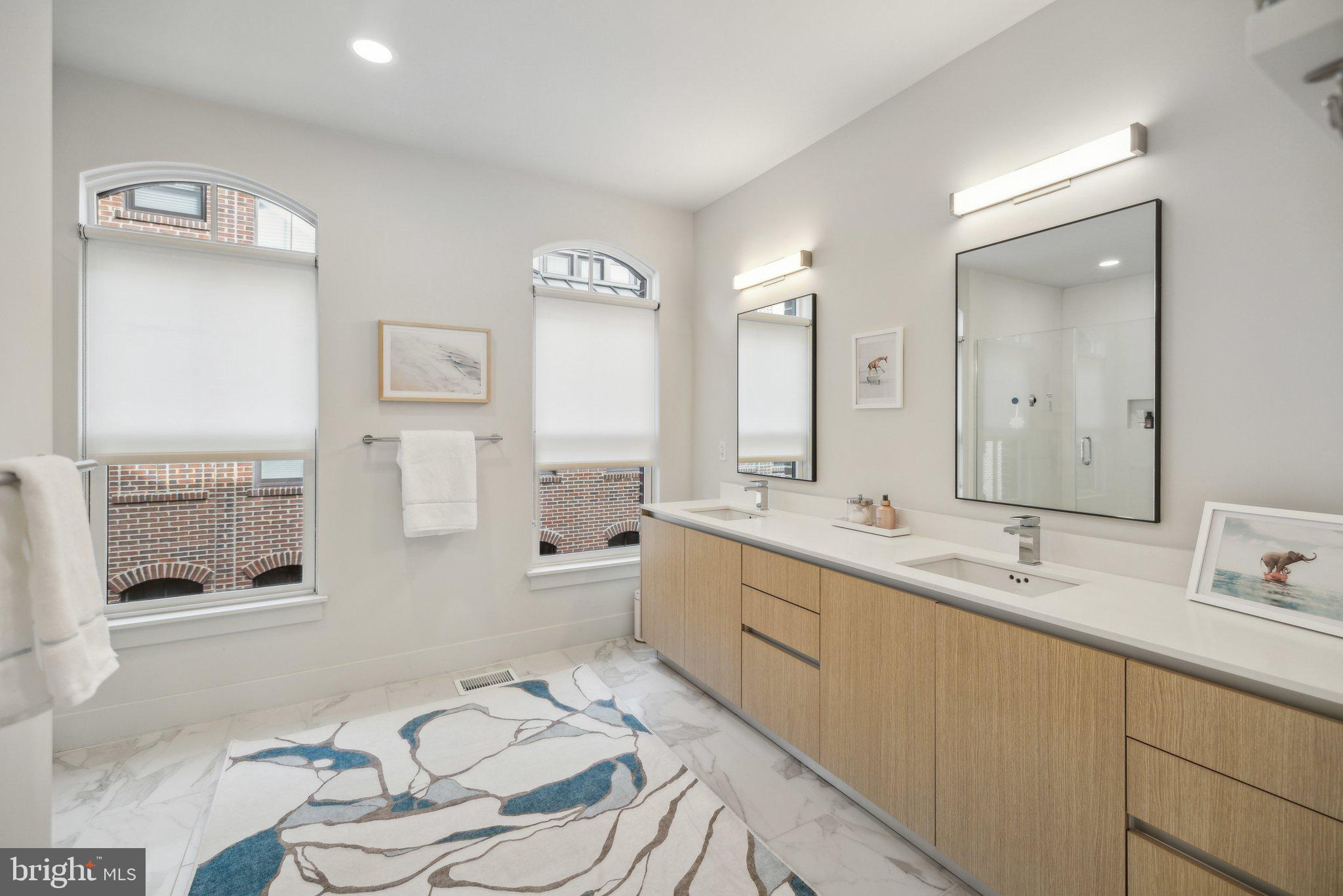1309 E Street Southeast, Unit 36 Washington, DC 20003 - Photo 17 of 36 a spacious bathroom with a double vanity sink a mirror and a shower