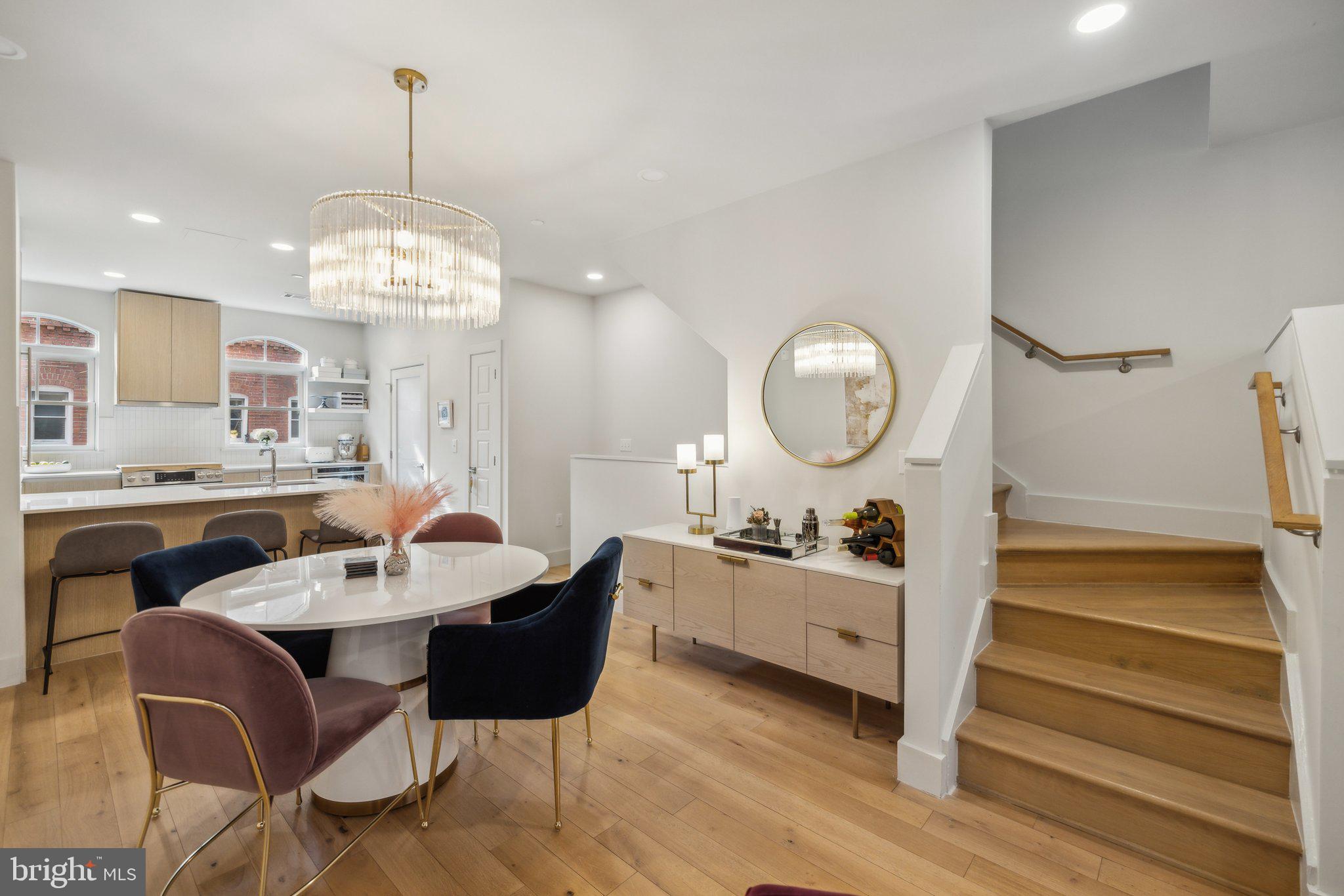 1309 E Street Southeast, Unit 36 Washington, DC 20003 - Photo 9 of 36 a dining room with wooden floor a chandelier a wooden table and chairs