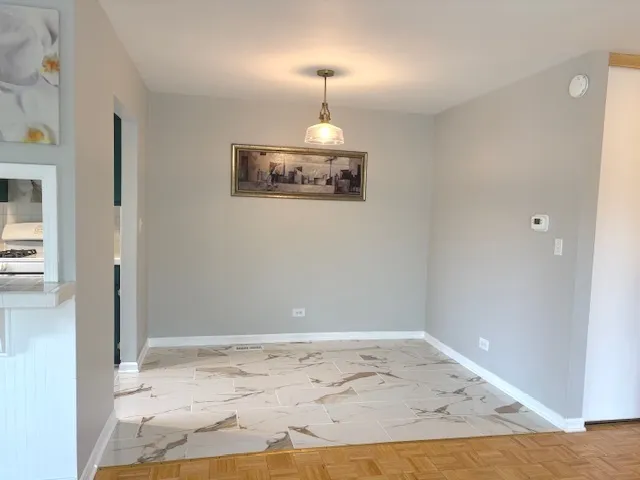 a view of a hallway with wooden floor and a chandelier