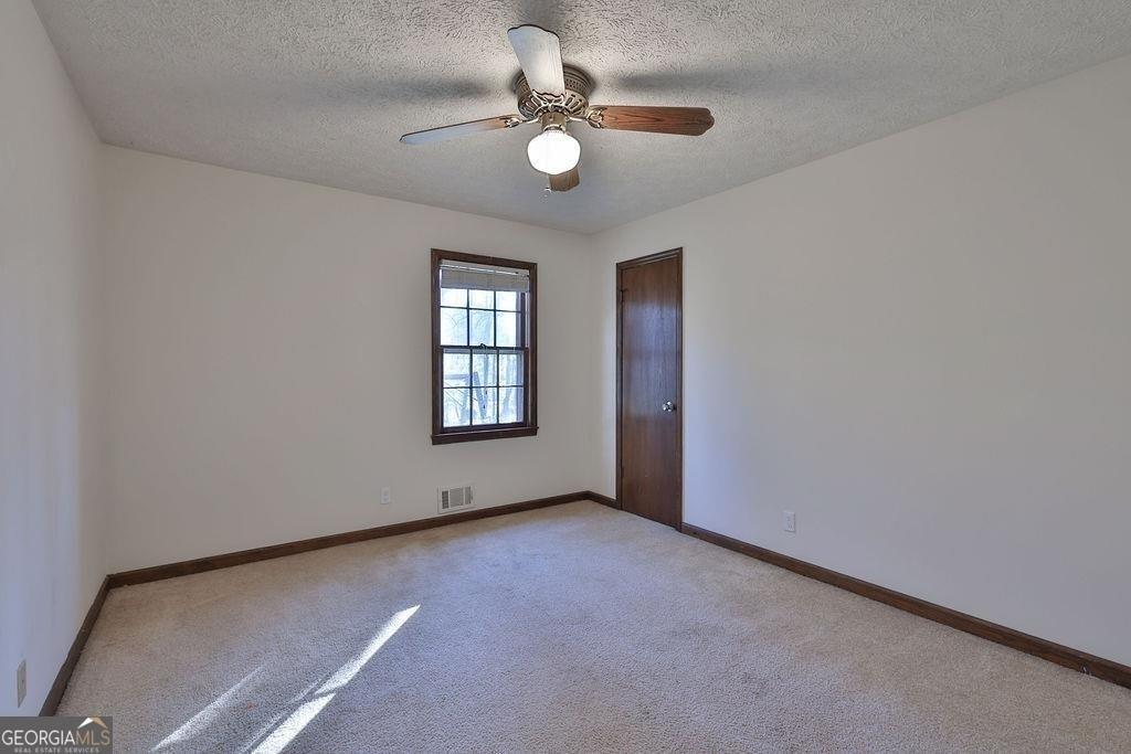 2733 Old Dawsonville Road Gainesville, GA 30506 - Photo 18 of 40 an empty room with windows and ceiling fan