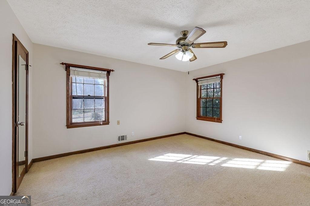 2733 Old Dawsonville Road Gainesville, GA 30506 - Photo 19 of 40 an empty room with windows and fan