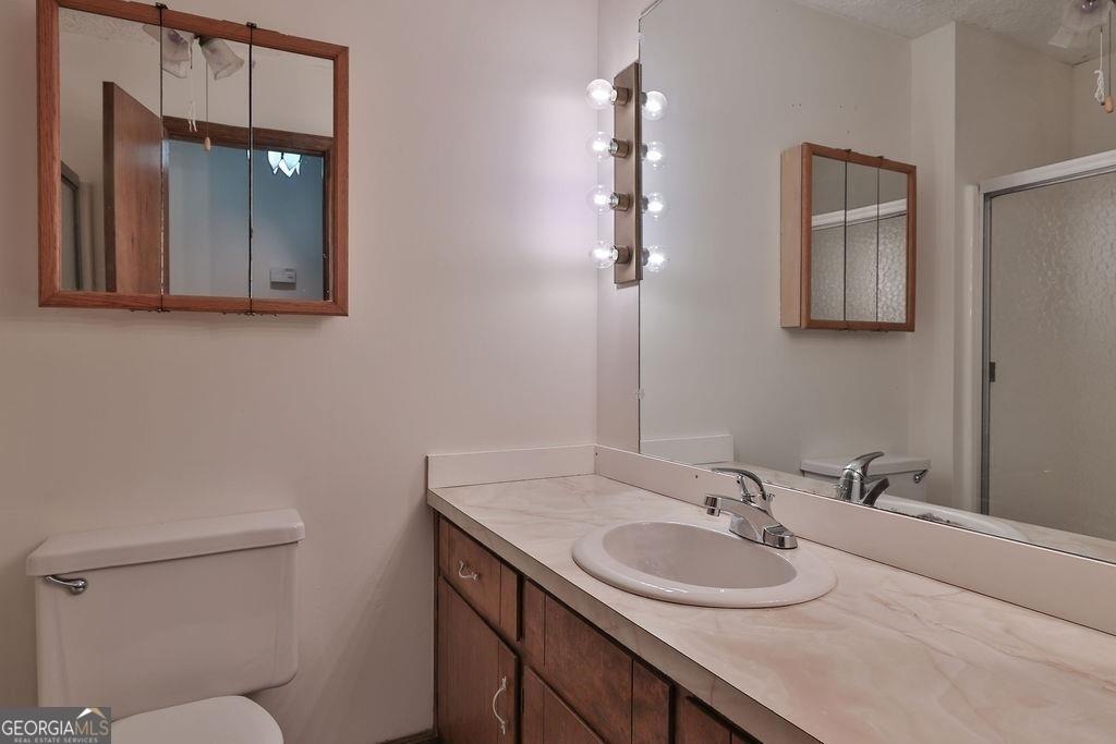 2733 Old Dawsonville Road Gainesville, GA 30506 - Photo 22 of 40 a bathroom with a toilet sink and mirror