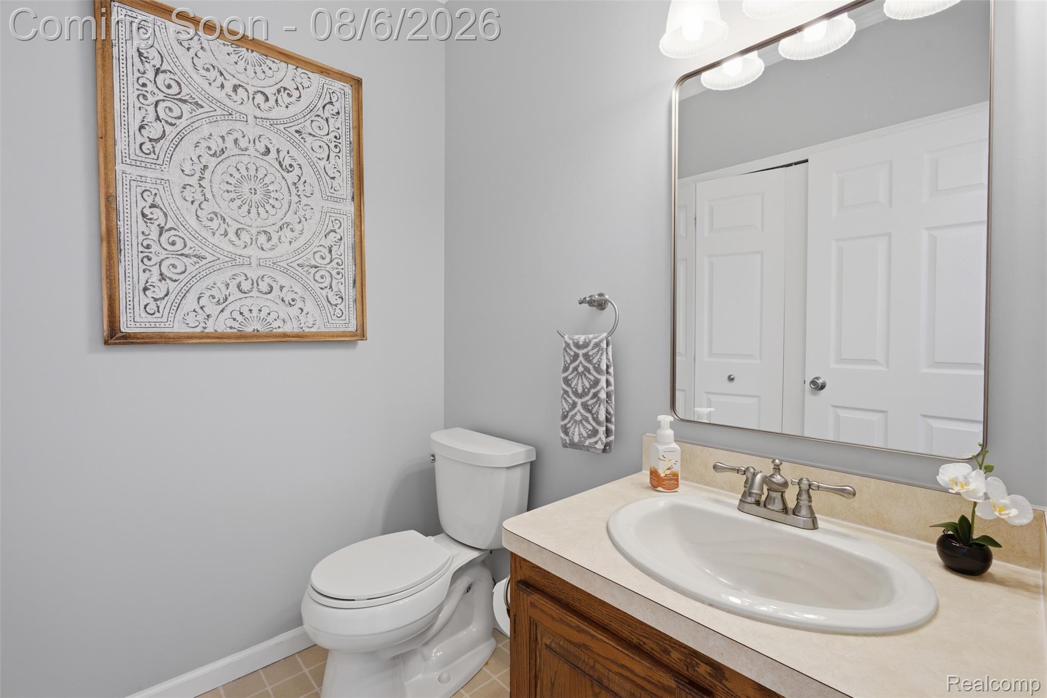 3585 Loon Lake Road Wixom, MI 48393 - Photo 12 of 40 Powder room featuring a single vanity with a laminate countertop, an undermount sink, and a brushed nickel faucet