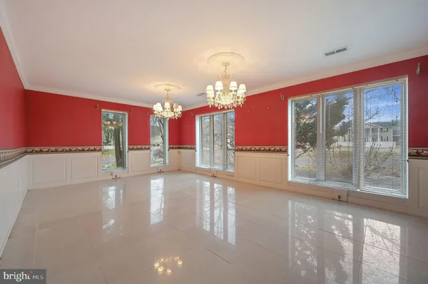 a view of a livingroom with a chandelier fan and windows