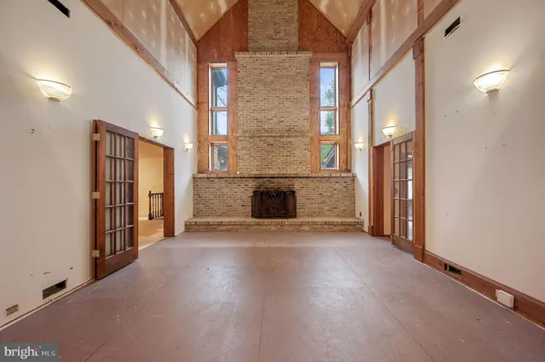 an empty room with wooden floor and a fireplace