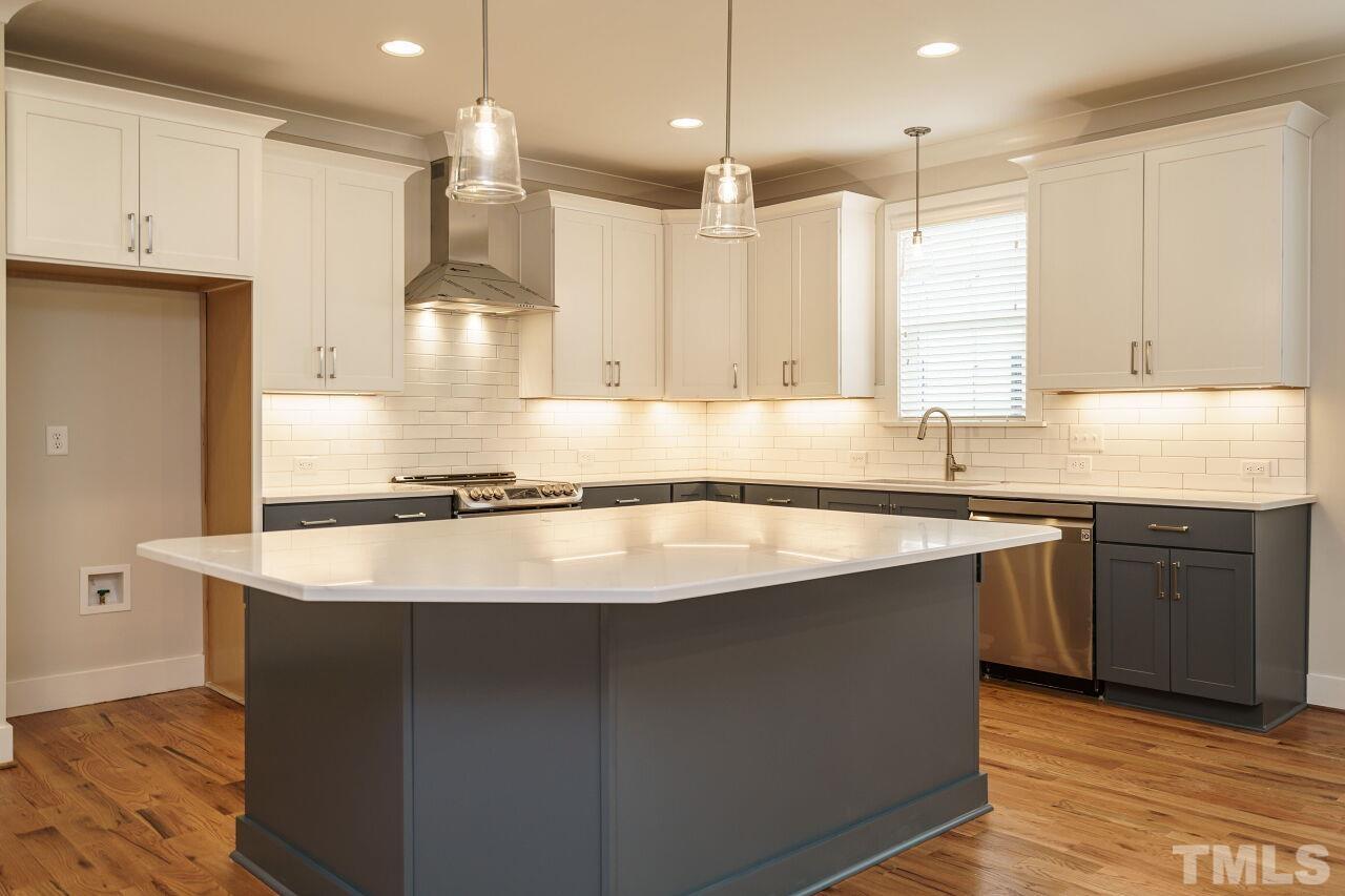 171 Adams Street Cary, NC 27513 - Photo 11 of 32 a kitchen with kitchen island granite countertop a sink a center island and cabinets