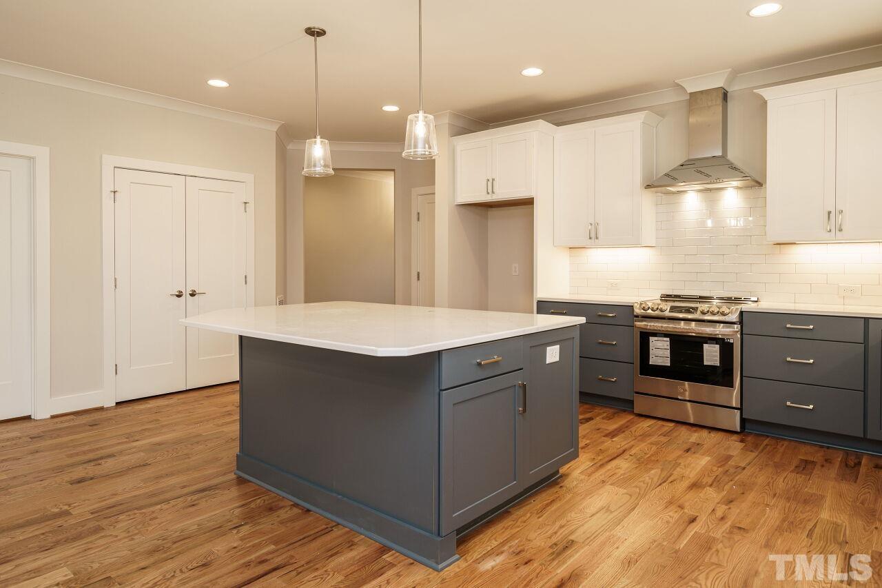171 Adams Street Cary, NC 27513 - Photo 12 of 32 a kitchen with stainless steel appliances granite countertop a stove a sink and a refrigerator