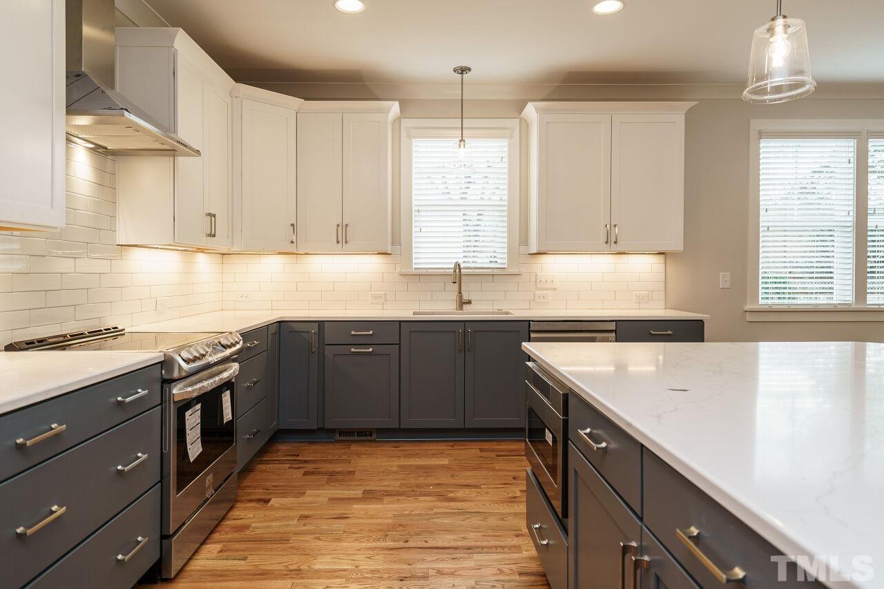 171 Adams Street Cary, NC 27513 - Photo 14 of 32 a kitchen with stainless steel appliances granite countertop a sink stove and cabinets