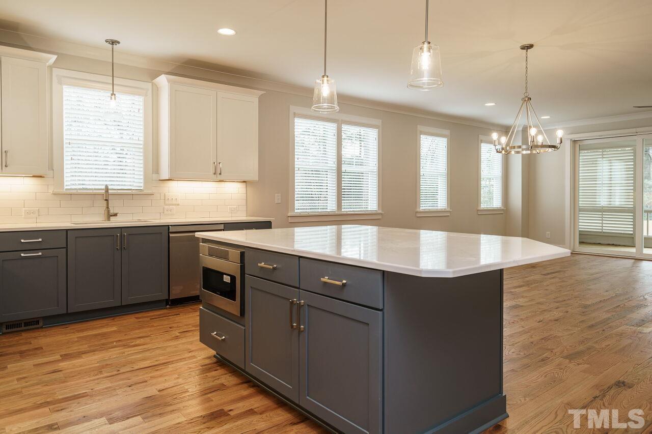 171 Adams Street Cary, NC 27513 - Photo 15 of 32 a kitchen with stainless steel appliances granite countertop a sink a counter space and a center island