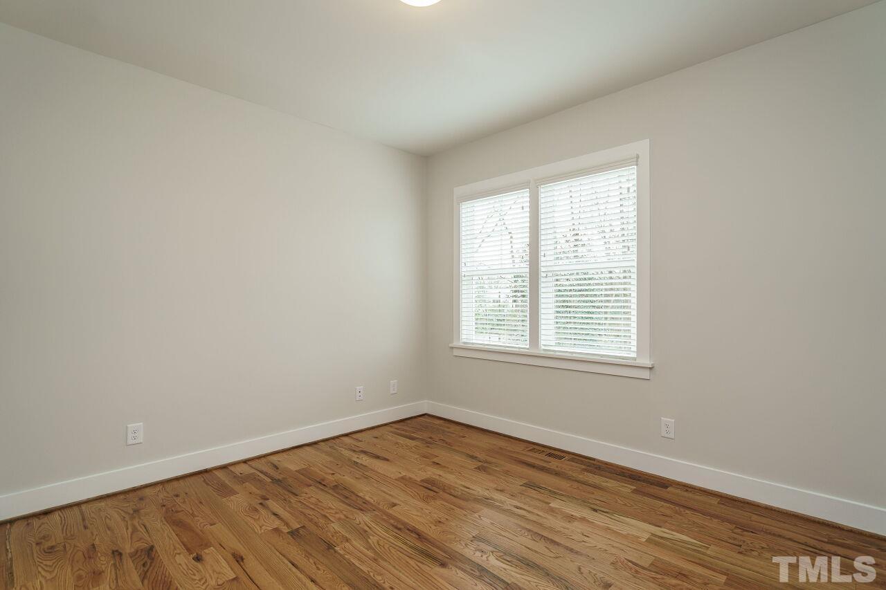 171 Adams Street Cary, NC 27513 - Photo 24 of 32 an empty room with wooden floor and windows