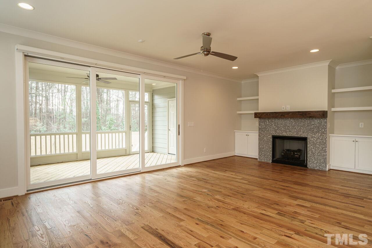 171 Adams Street Cary, NC 27513 - Photo 6 of 32 a view of an empty room with wooden floor fireplace and a window
