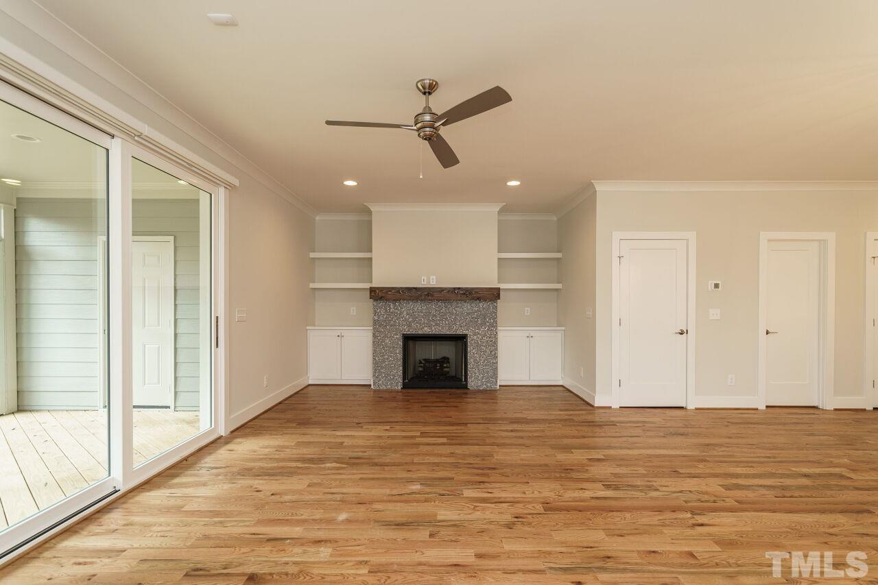 171 Adams Street Cary, NC 27513 - Photo 7 of 32 a view of a livingroom with a fireplace a ceiling fan and window
