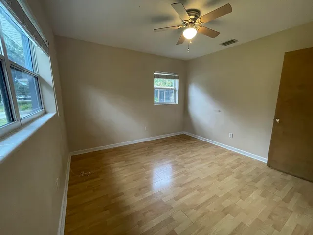 an empty room with a window and a fan