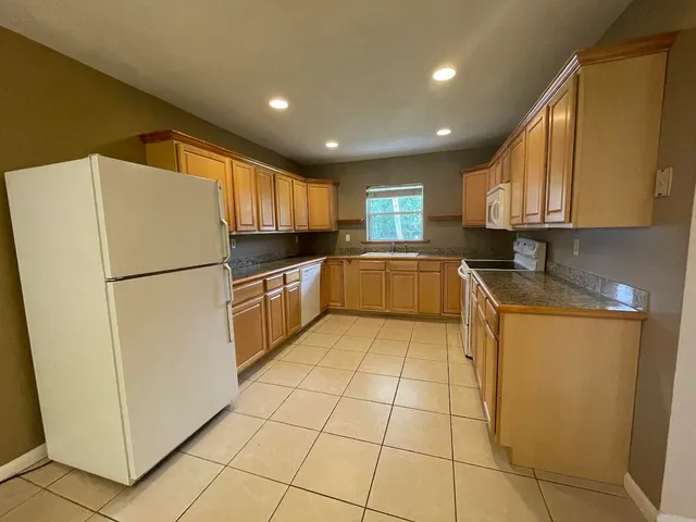 a kitchen with granite countertop a refrigerator and a sink