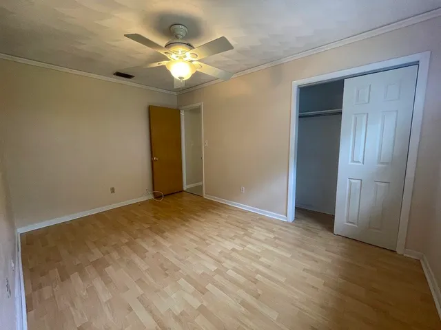 a view of an empty room with a chandelier fan