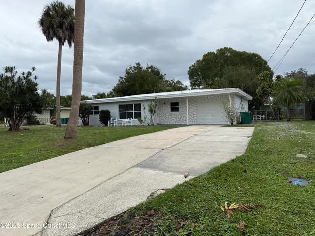 a front view of a house with a garden and yard