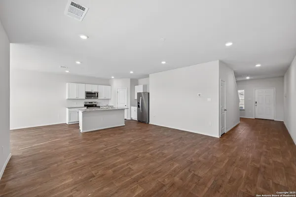 a view of kitchen with kitchen island wooden floor and center island