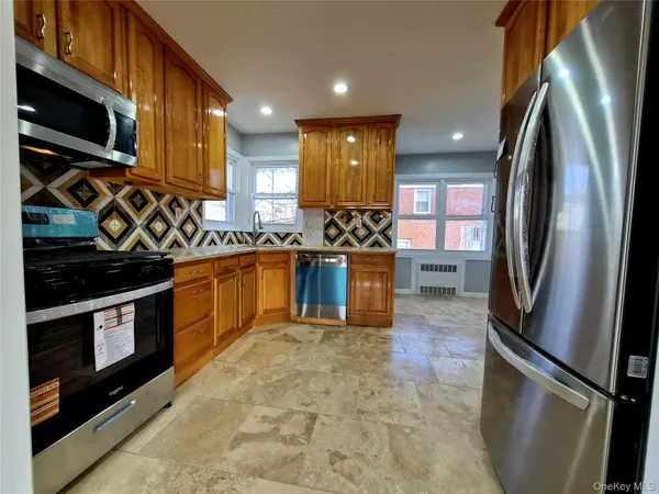 a kitchen with stainless steel appliances granite countertop a stove a sink and a refrigerator