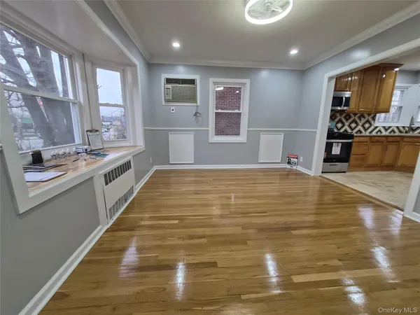 a large white kitchen with kitchen island a sink stainless steel appliances and window
