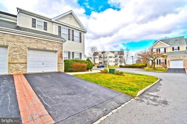 a view of a white house with a large pool and large trees