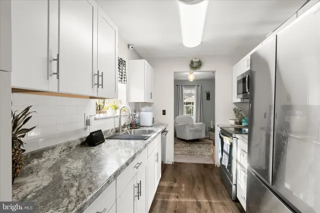 a kitchen with sink refrigerator and cabinets