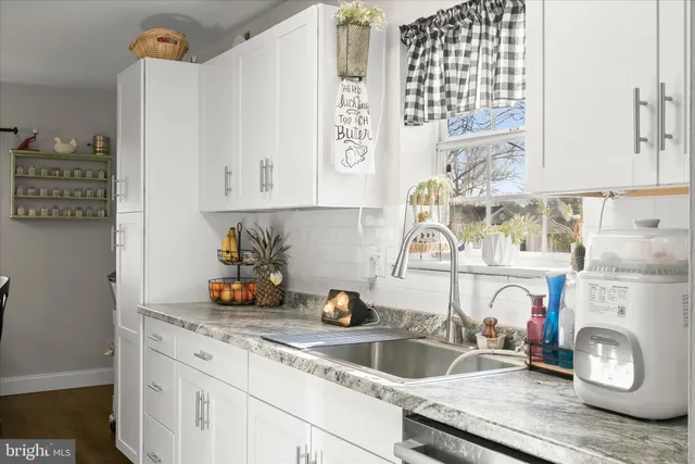 a kitchen with a sink a stove and cabinets