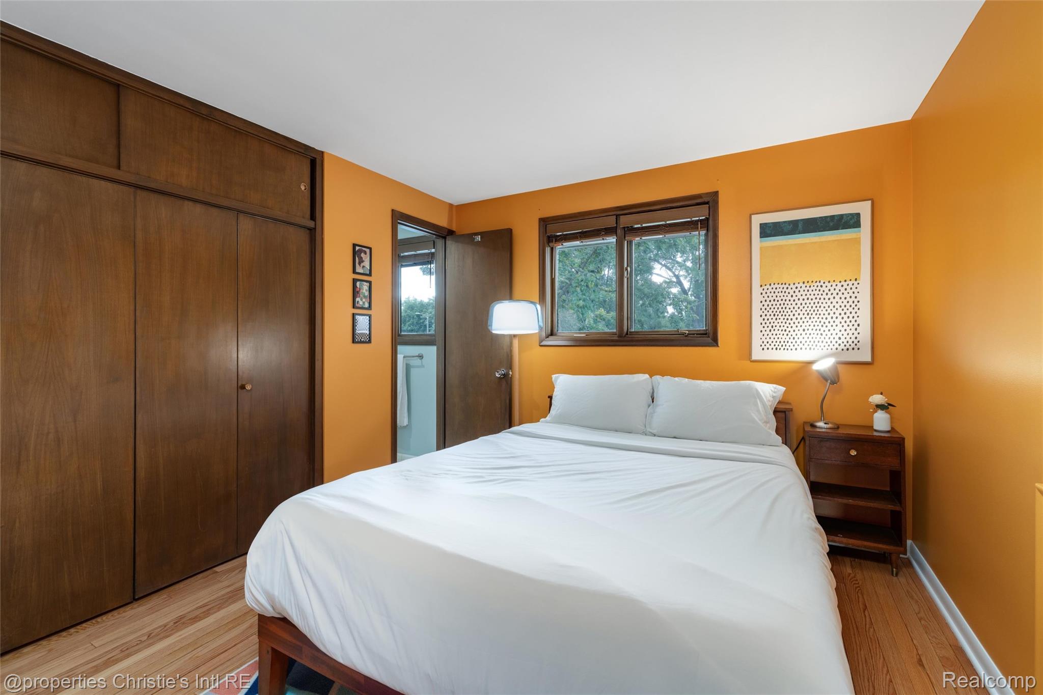 2771 West Seven Mile Road Detroit, MI 48221 - Photo 42 of 57 Bedroom featuring wood-finish flooring, a double window with wood trim, and a built-in wood-finish closet with overhead storage