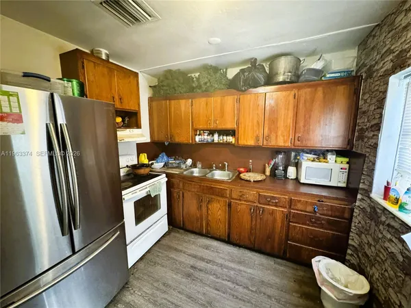 a kitchen with stainless steel appliances a sink cabinets and a refrigerator